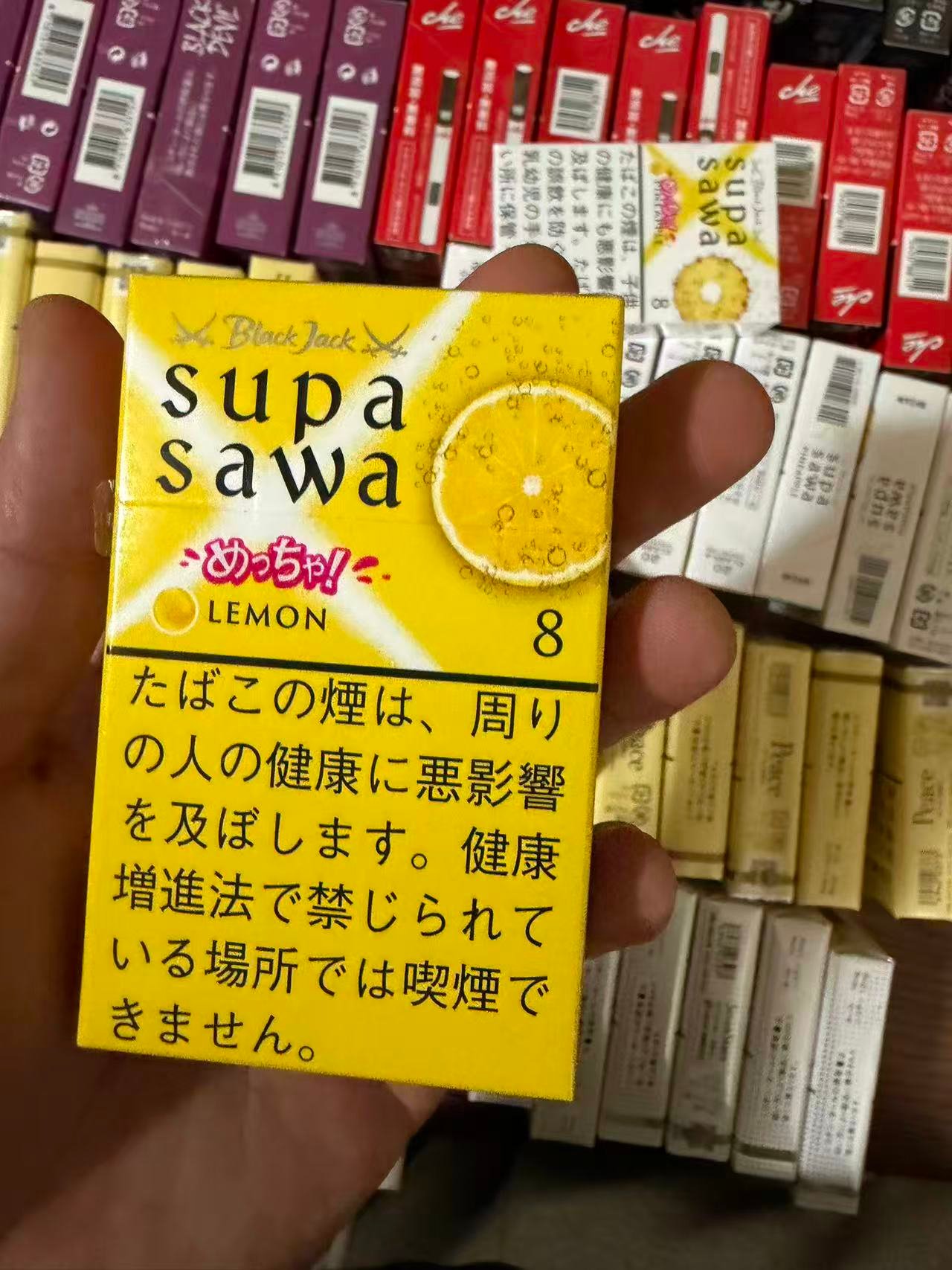 Supasawa Lemon 8mg pack held over a display of cigarette packs