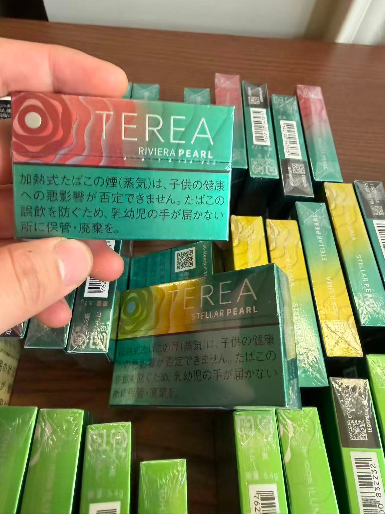 TEREA Riviera Pearl pack held over a display of TEREA products