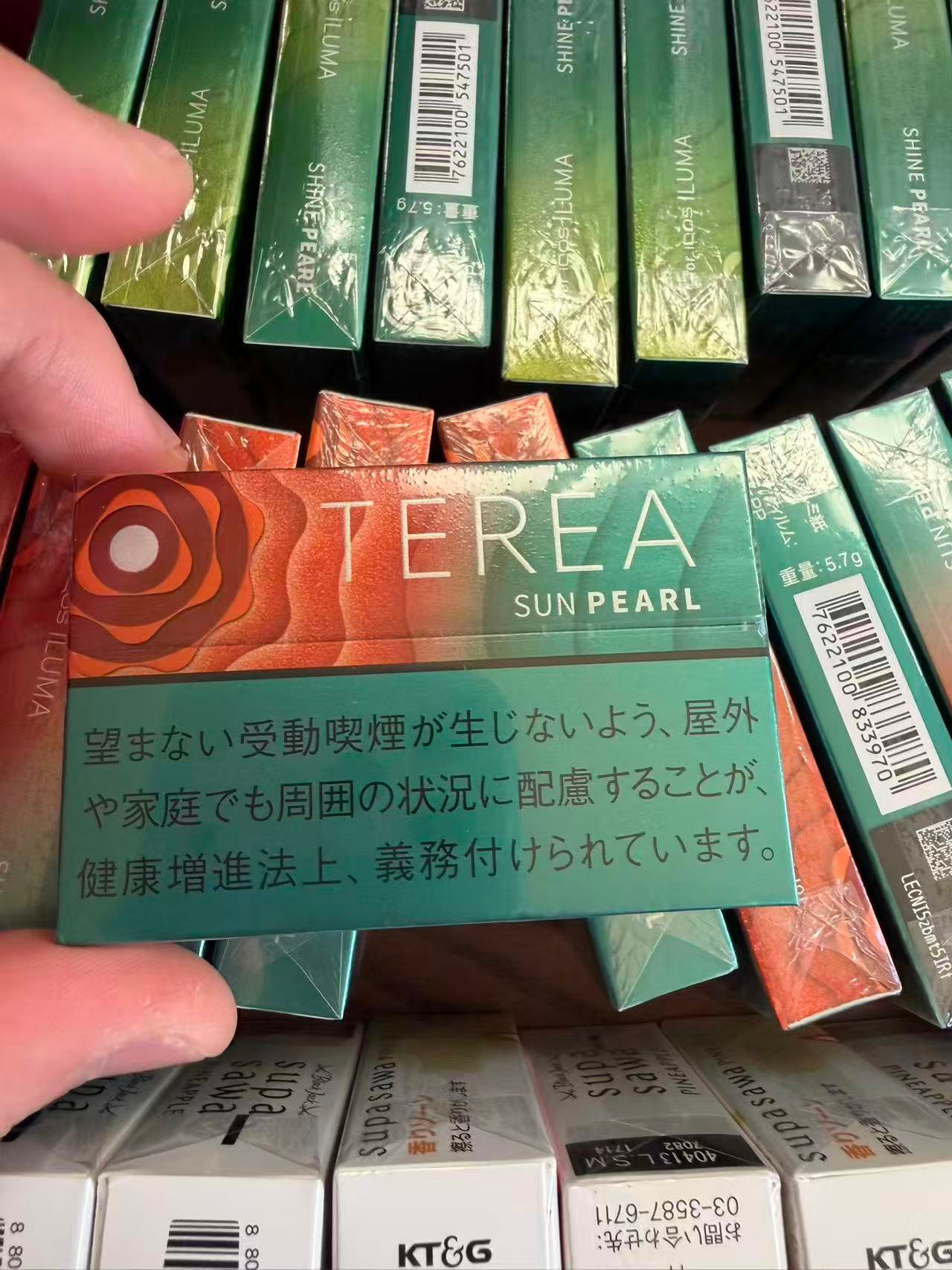 TEREA Sun Pearl pack held over a display of TEREA products